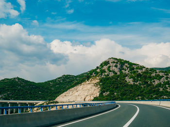 Road by mountain against sky