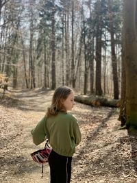 Full length of woman standing on footpath in forest