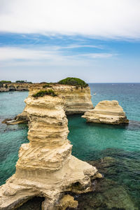 Scenic view of rocks in sea against sky