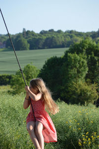 Rear view of woman on field against sky