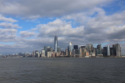 Modern buildings in city against cloudy sky