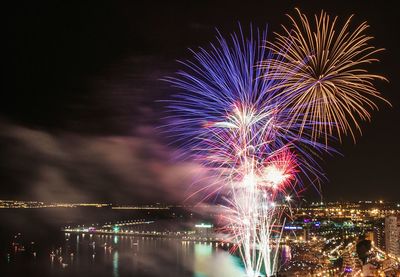 Firework display over sea at night