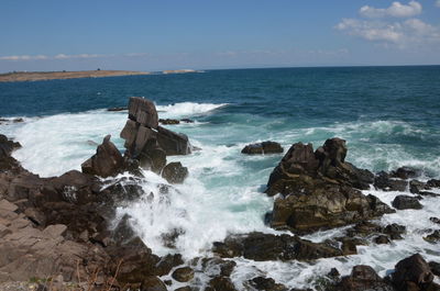 Scenic view of rocks in sea against sky