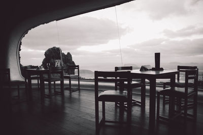 Empty chairs and tables in restaurant against window