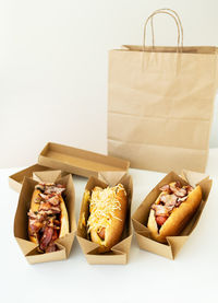 Food delivery concept. various types of hot dogs in craft packaging on the table.