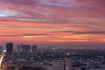 Aerial view of buildings against cloudy sky during sunset