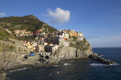 Scenic view of sea and cliff against blue sky