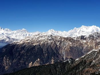 Scenic view of snowcapped mountains against clear blue sky