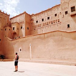 Side view of man standing outside palace