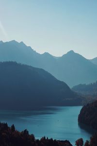 Scenic view of sea and mountains against clear sky