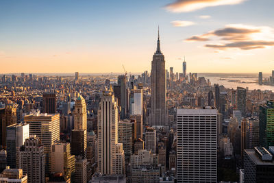 Modern buildings in city against sky during sunset