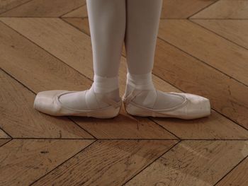 Low section of woman standing on hardwood floor