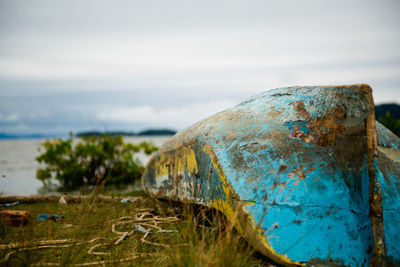 Abandoned upside down boat on field