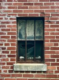 Low angle view of window on brick wall