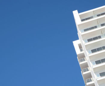 Low angle view of buildings against clear blue sky