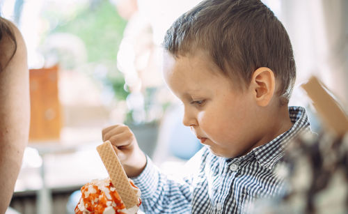 Side view of young woman eating food at home