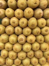 Full frame shot of stacked kiwis at market