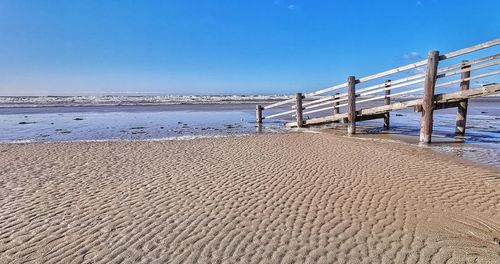 Scenic view of beach against clear blue sky