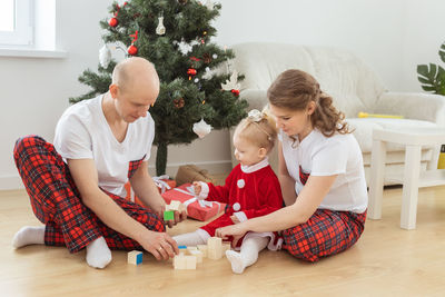 Mother and father playing with daughter at home