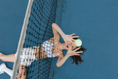Portrait of young woman playing with ball