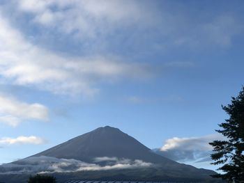 Low angle view of volcanic mountain, mt. fuji, against cloudy sky