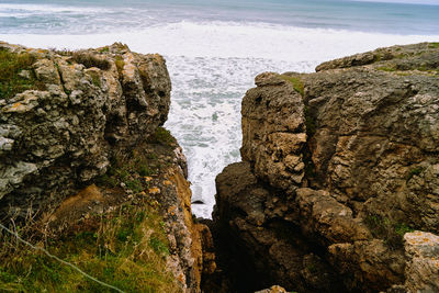 Rock formation on beach against sky