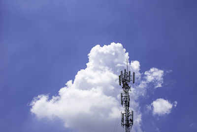 Low angle view of communications tower against blue sky