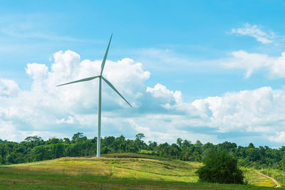 Windmill on field against sky