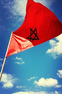 Low angle view of american flag against blue sky