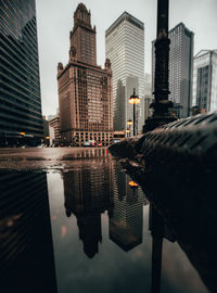 Reflection of buildings in city against sky