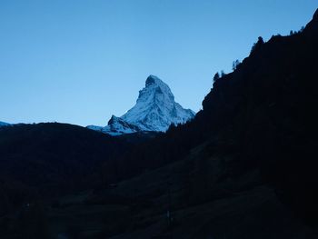 Scenic view of snowcapped mountains against clear blue sky