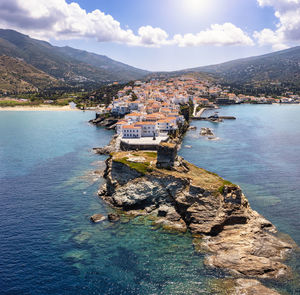 Scenic view of sea by townscape against sky