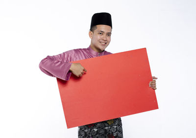 Smiling young man standing against white background