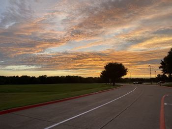 Empty road against sky during sunset