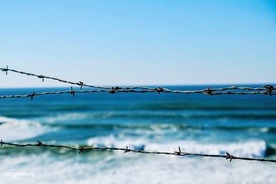 Close-up of barbed wire against clear sky