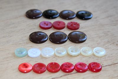 Colorful buttons arranged on wooden table