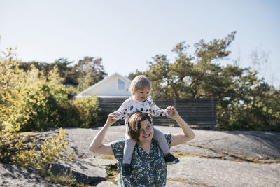 Mother carrying daughter on shoulders