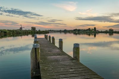 Sunset over a wooden pier at river rotte in holland