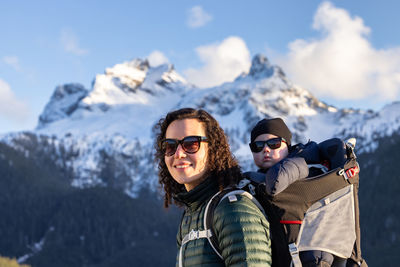 Portrait of woman wearing sunglasses while standing against mountain