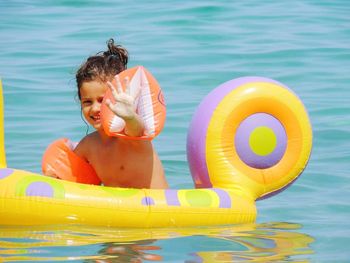 Portrait of shirtless girl with inflatable ring in sea