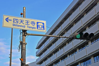 Low angle view of road sign against sky