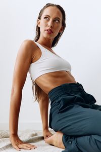 Portrait of young woman standing against white background