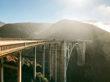 Scenic view of dam and mountains against sky