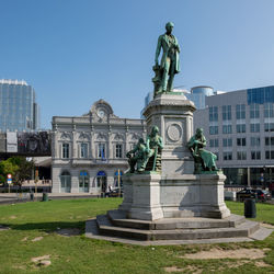 Statue in city against clear sky