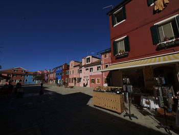 Buildings in city against clear blue sky