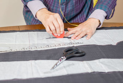 Midsection of man holding paper on table