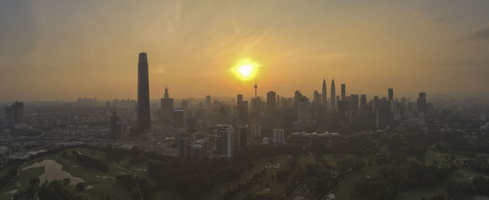 Panoramic view of city buildings against sky during sunset