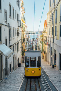 Tram on street amidst buildings in city