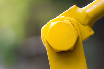 Close-up of yellow metal against wall