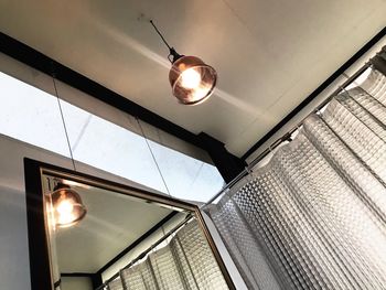 Low angle view of illuminated pendant light hanging from ceiling